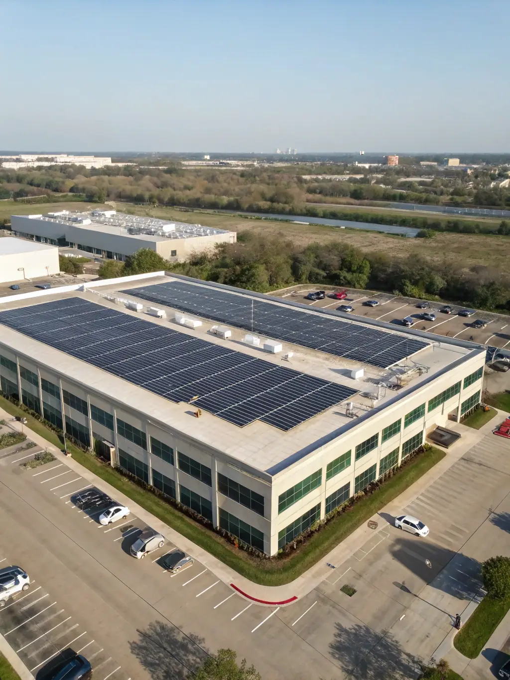 A modern industrial building with a large solar panel array on its roof, illustrating the scale and efficiency of solar energy for commercial use.